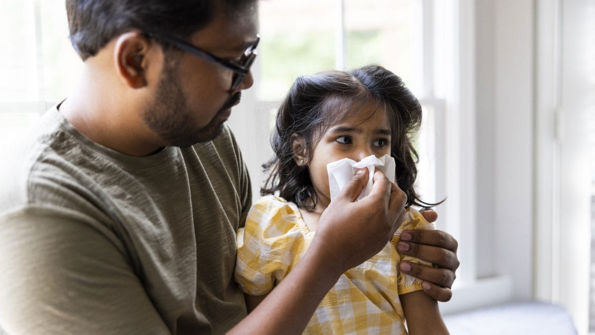 Father blowing daughter's nose