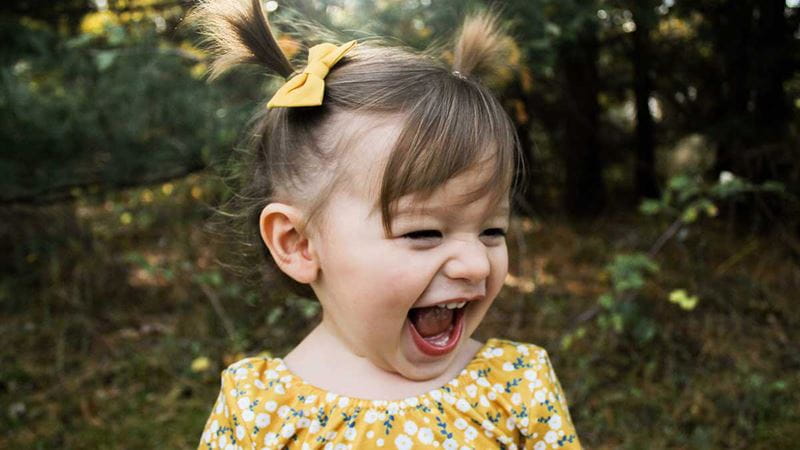 Toddler open mouth smiling outdoors