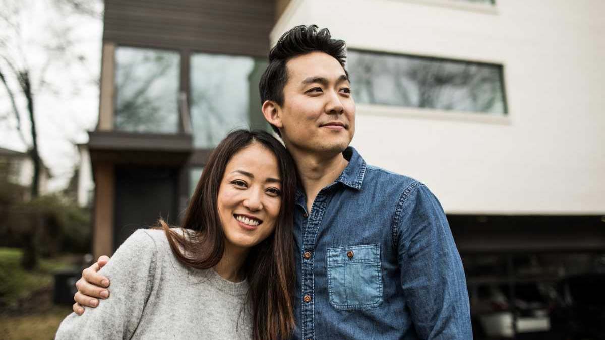 A happy couple outside their house
