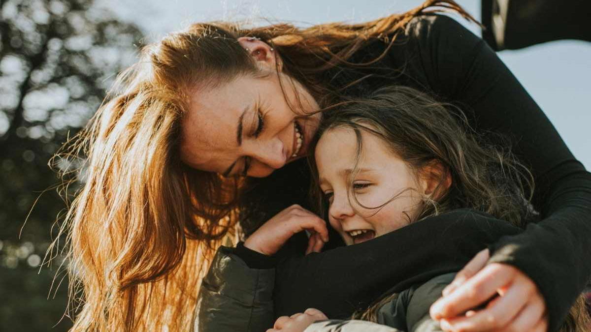 A young mum hugging her pre-teen daughter