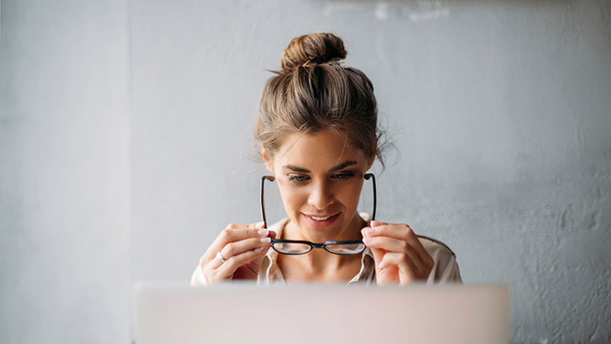 Young woman removing her glasses