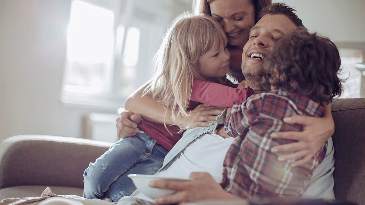 Family having a group hug on couch