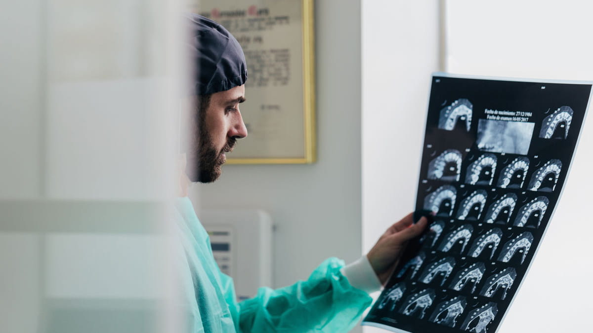Orthodontist examining jaw and tooth xrays