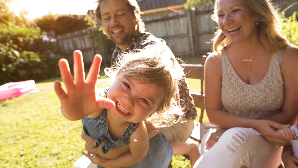 Young family relaxing in backyard