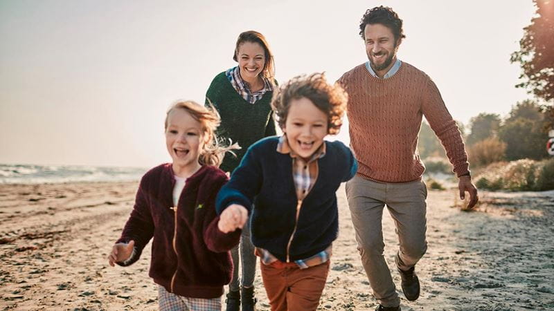 Parents chasing kids on beach