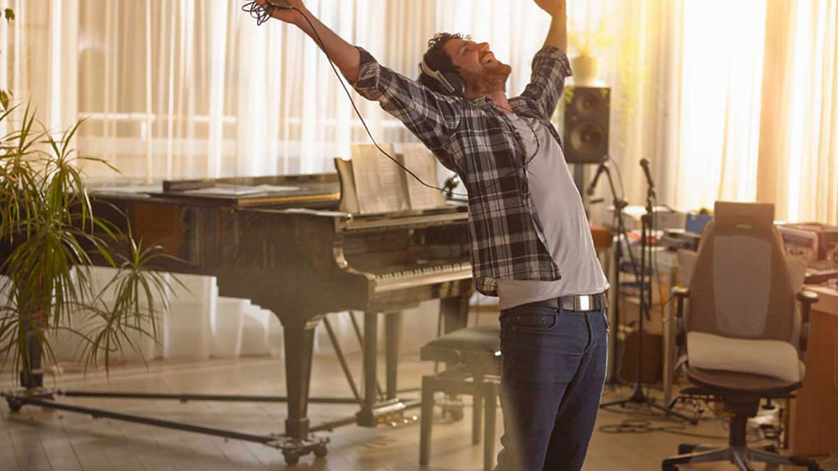 Happy young musician listening to headphones