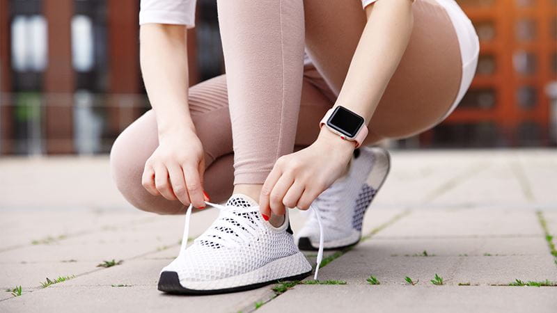 Woman tying laces on running shoes