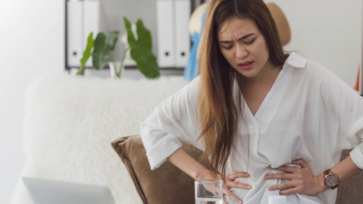 Woman wincing with stomach pain