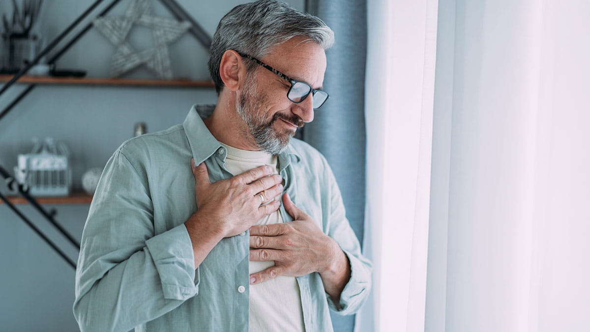 Older man holding chest