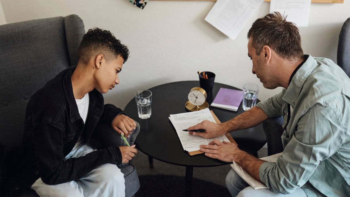Father and son looking at a form