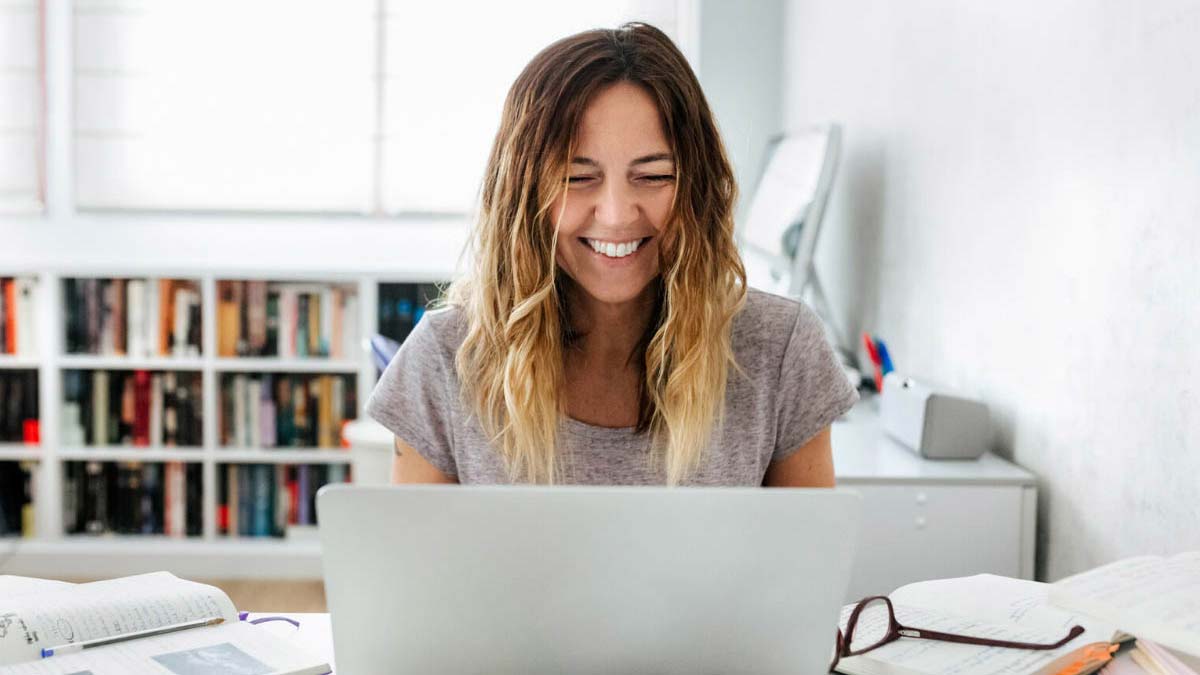Young woman smiling in front of laptop