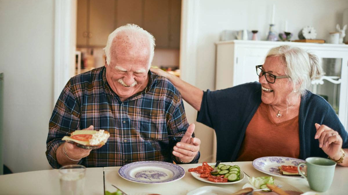 Older couple laughing together over a meal