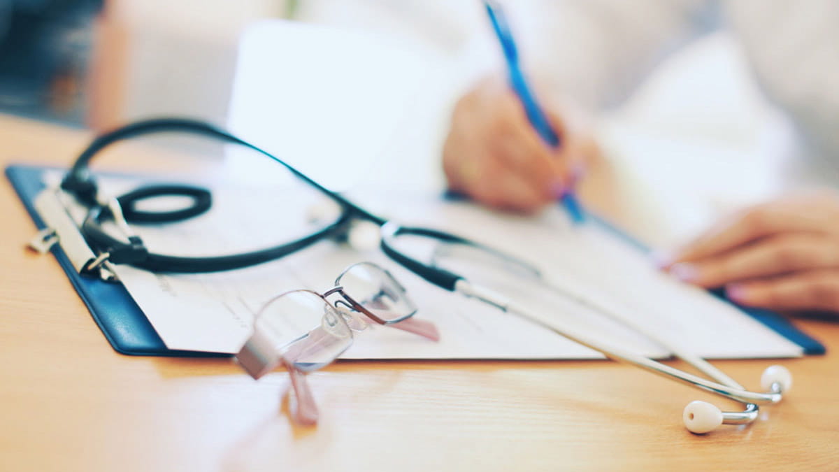 Doctor writing on pad