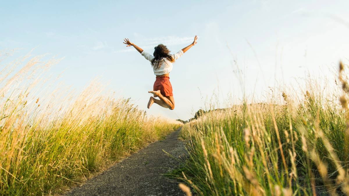 Young woman jumping for joy in the air in spring because she has spring cleaned her health