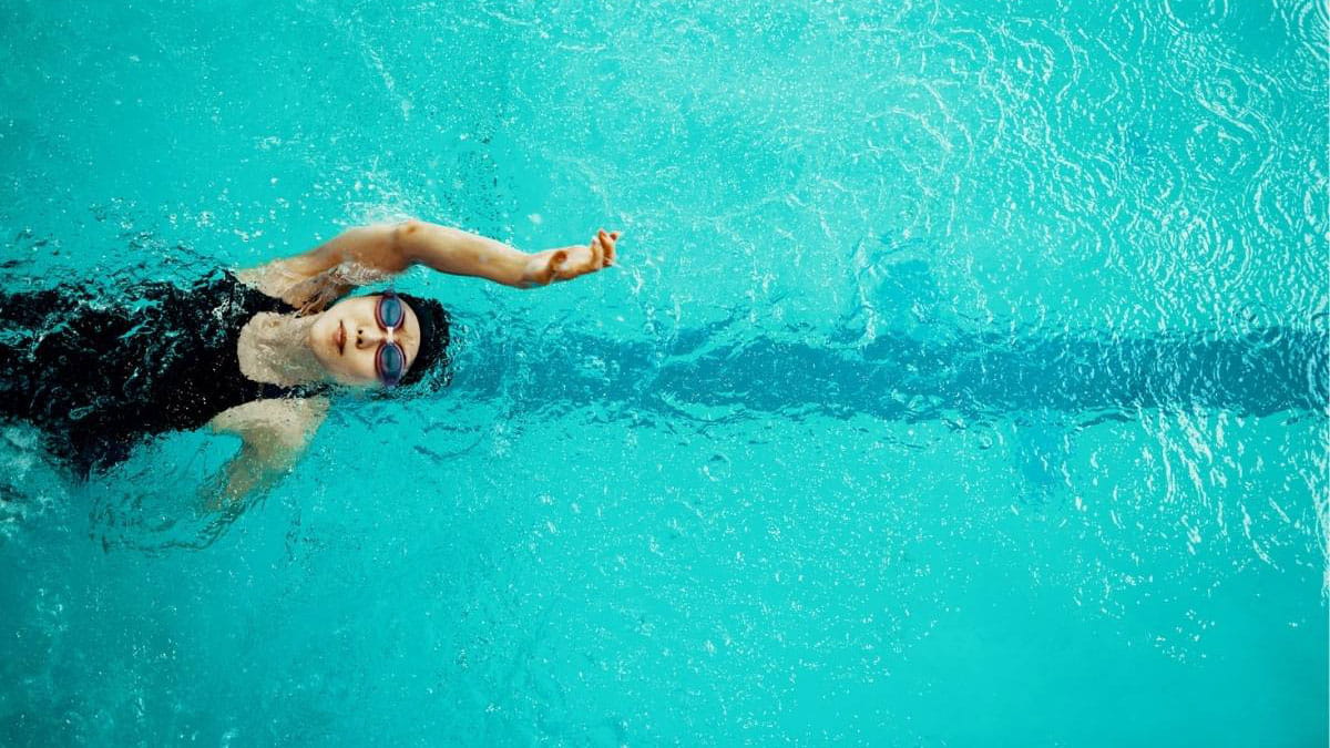 Woman in goggles swimming in pool