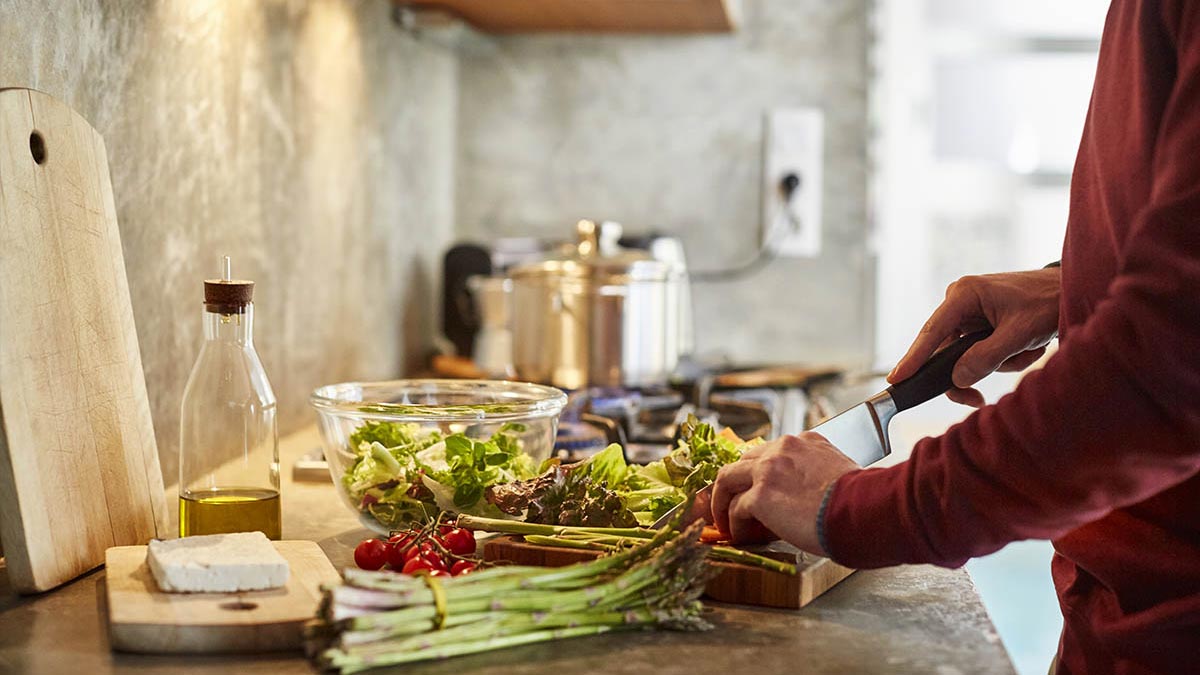 Person in kitchen making a salad