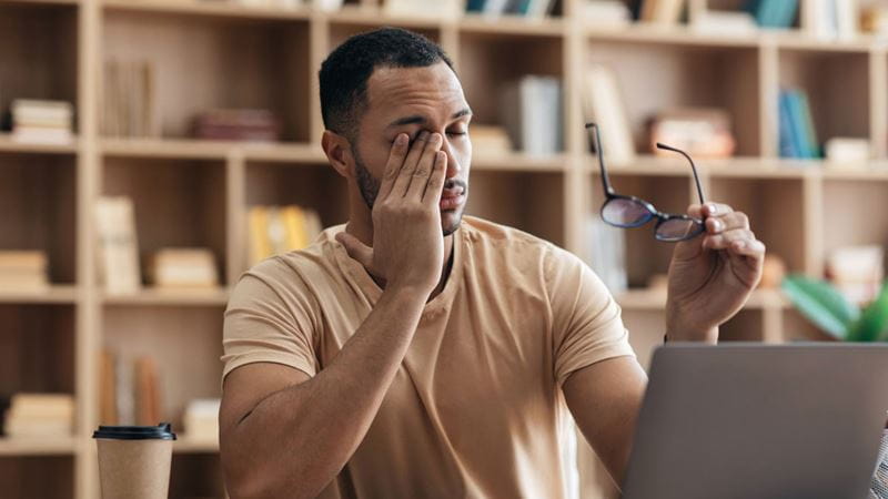 Man taking off his glasses and rubbing his eyes