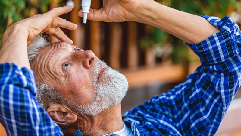Man putting in eyedrops