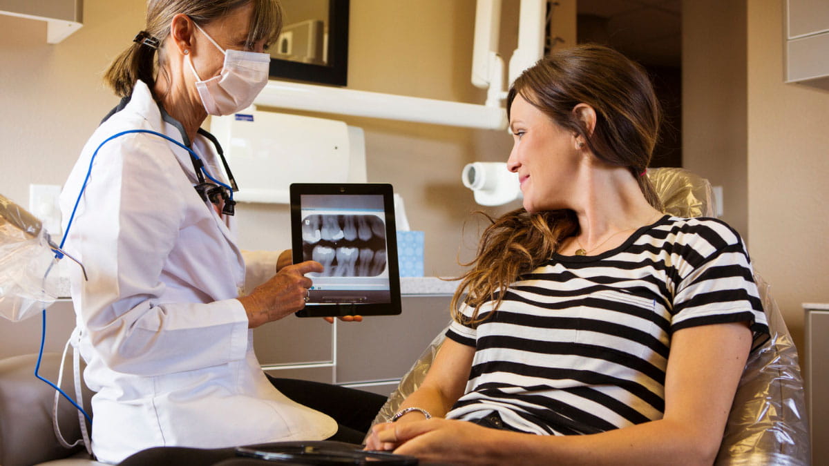 Dentist showing a female patient a tooth x-ray