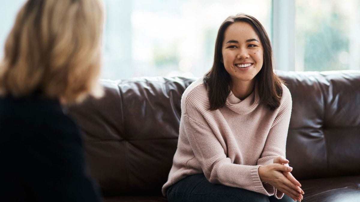 A young woman sitting on a couch and talking to the psychologist