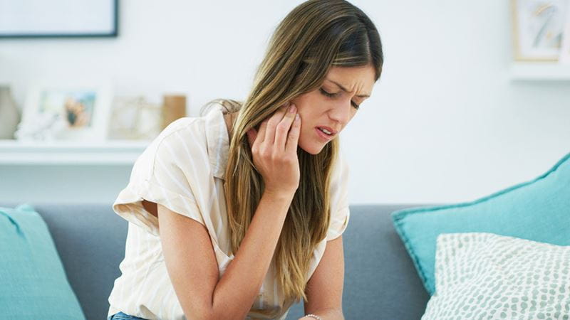 Woman in pain after wisdom teeth removal