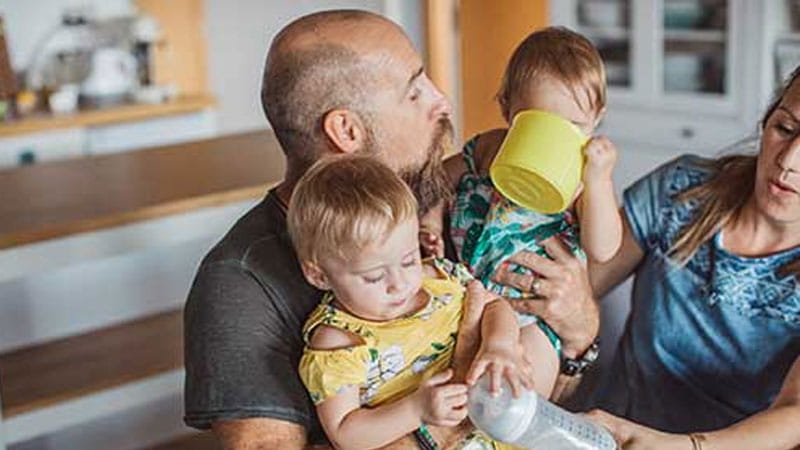 Father holding kids in kitchen