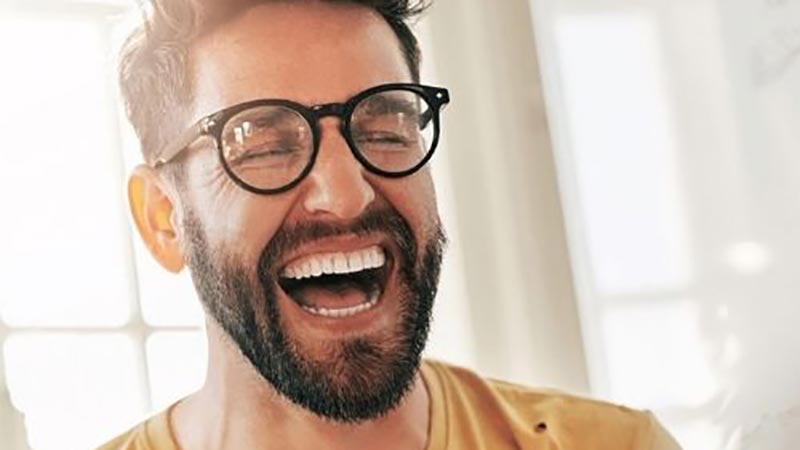 Man with glasses laughing