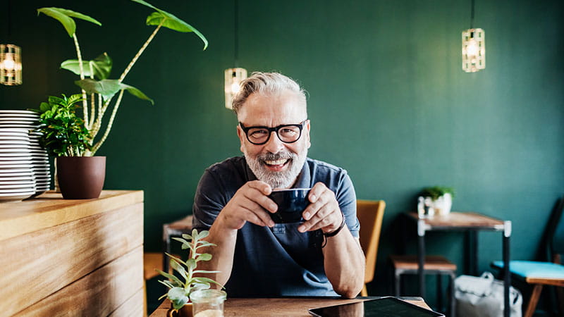 Smiling man in glasses in cafe