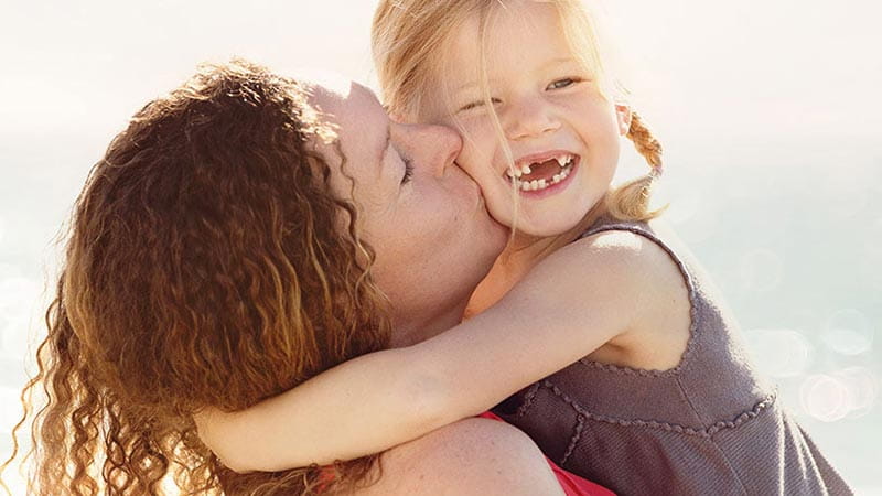 Woman kissing daughter