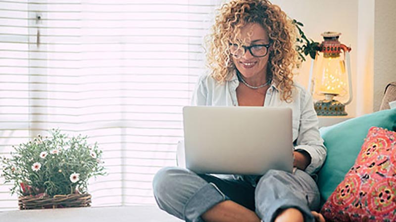woman-sitting-on-couch-using-laptop