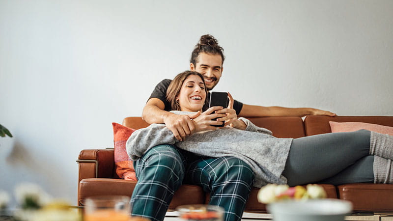 Young couple smiling on phone