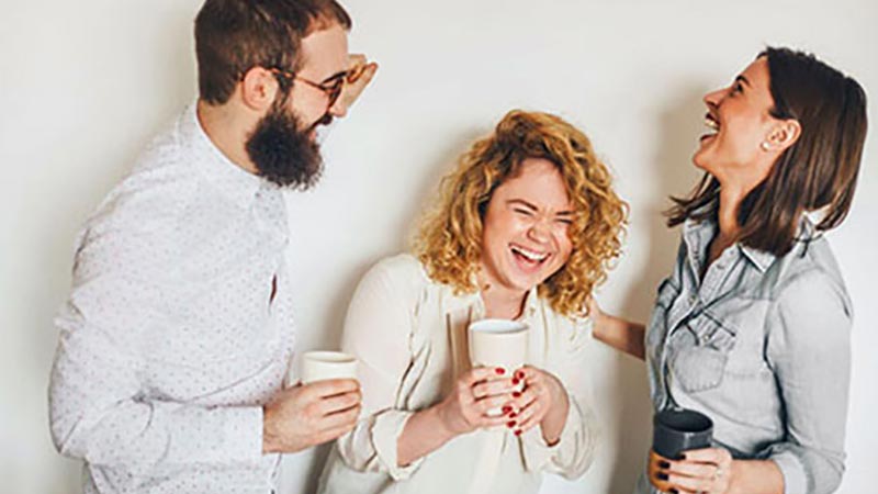 A young man and two young women laughing