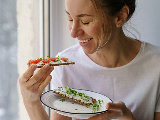 Woman smiling eating toast