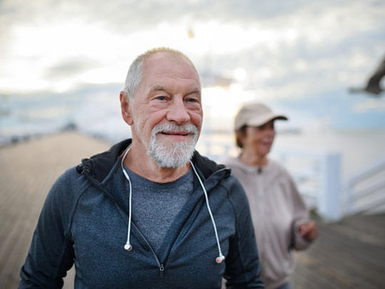 Elderly couple walking on pier