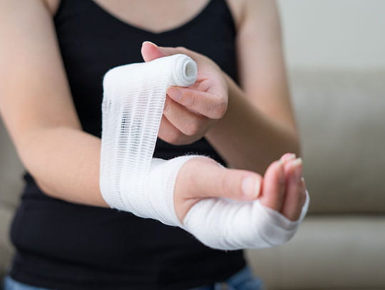 Woman bandaging her hand