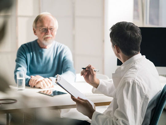 Doctor speaking to elderly man
