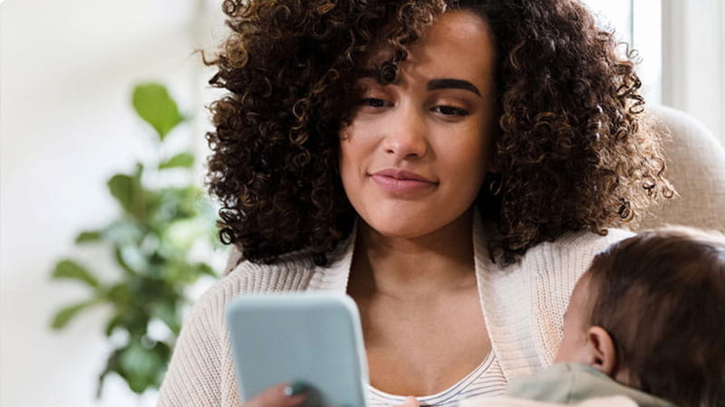 Mother holding child while on the phone
