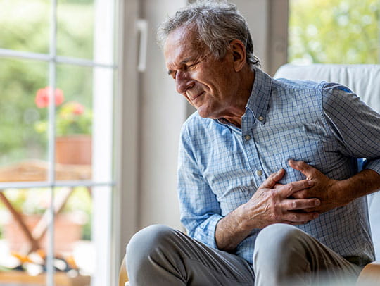 Older man holding chest