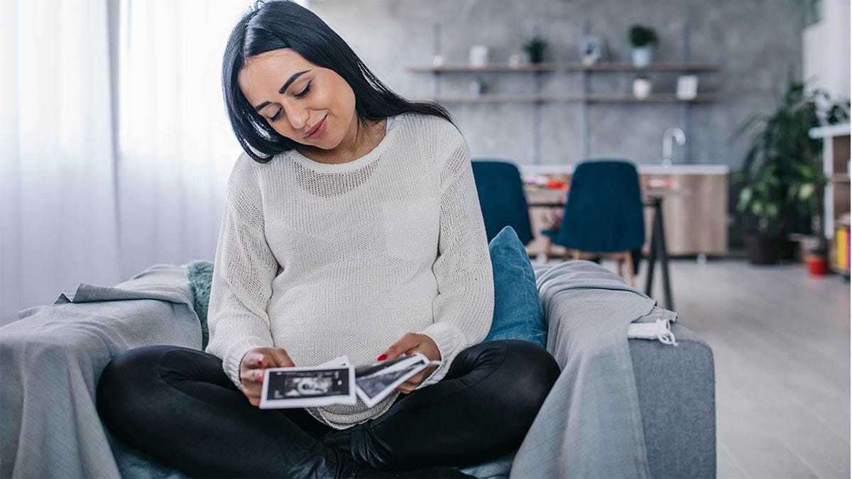 Pregnant woman looking at ultrasound photos