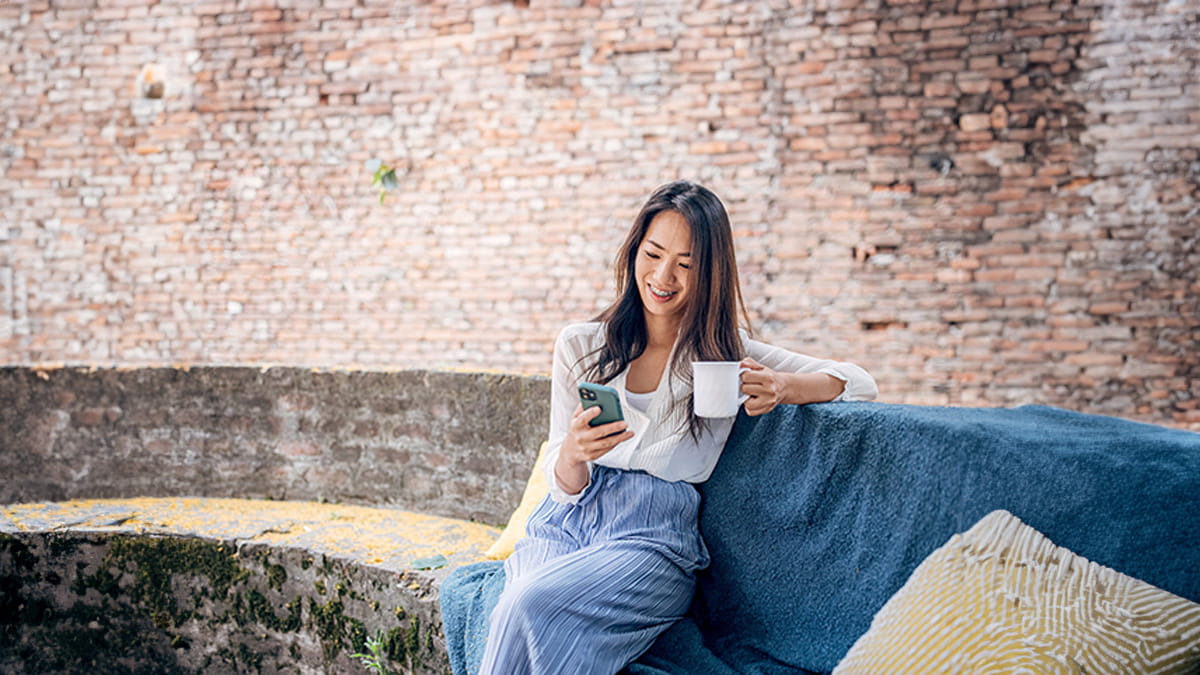 Woman sitting on a couch drinking a coffee