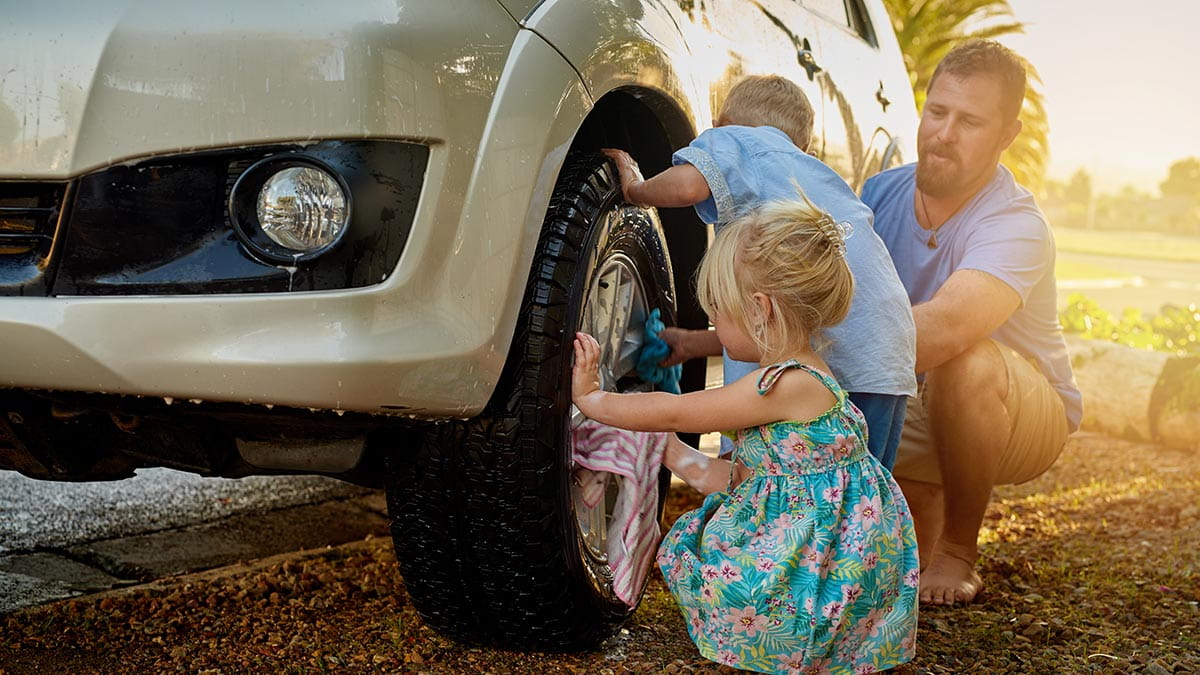 Kids helping dad change car tyre