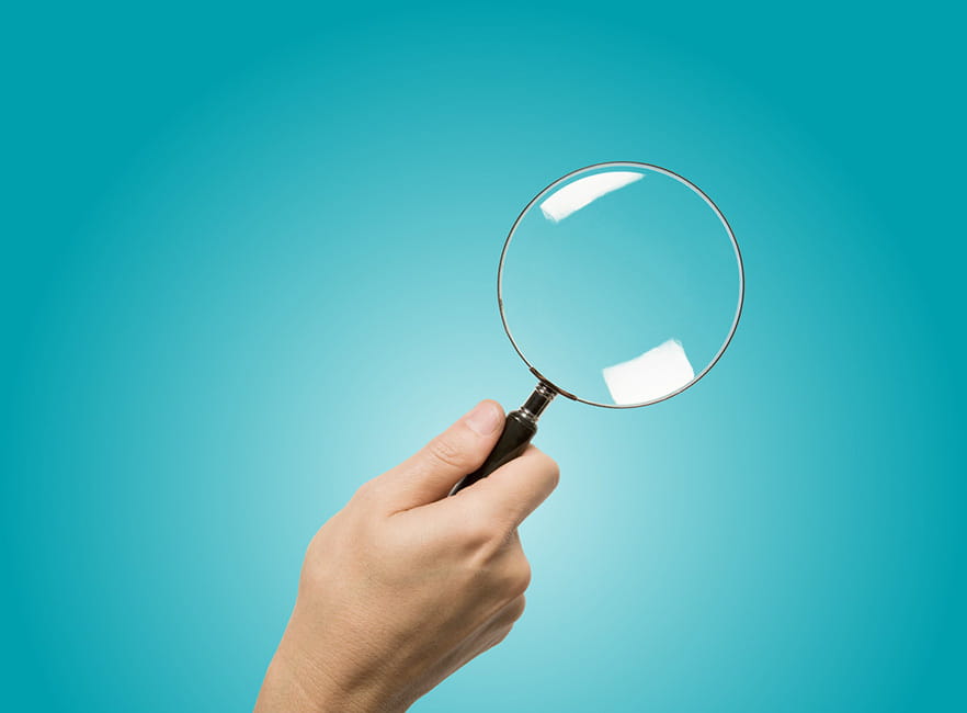 Hand holding magnifying glass