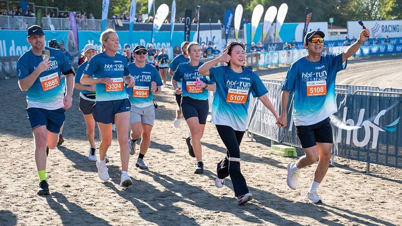Group running through the finish line
