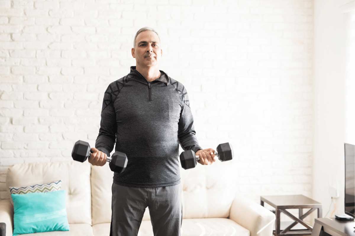 Man in his 50s exercising with handweights at home