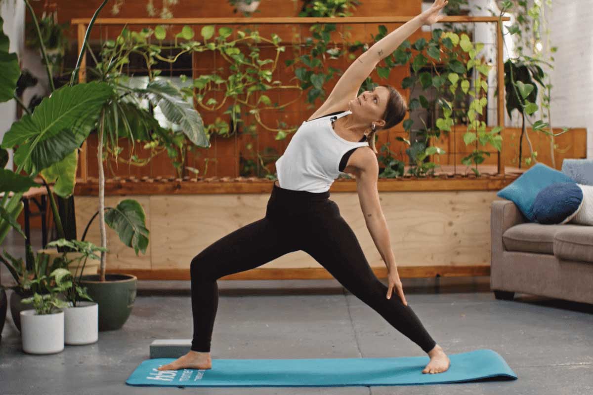 Young woman practising reverse warrior pose in yoga