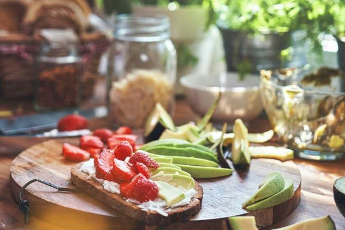 Healthy breakfast toast with cottage cheese, strawberries and avocado on a kitchen bench