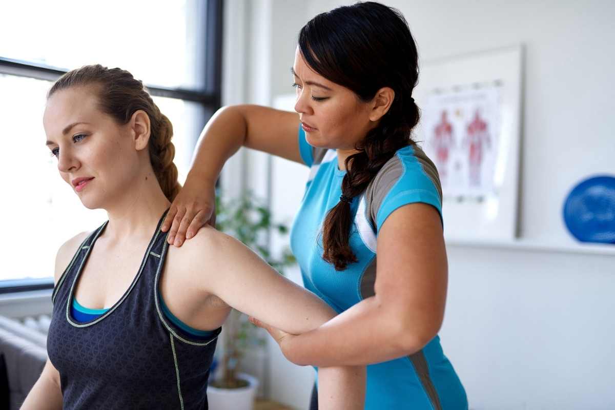 A physiotherapist working with her client to treat shoulder pain