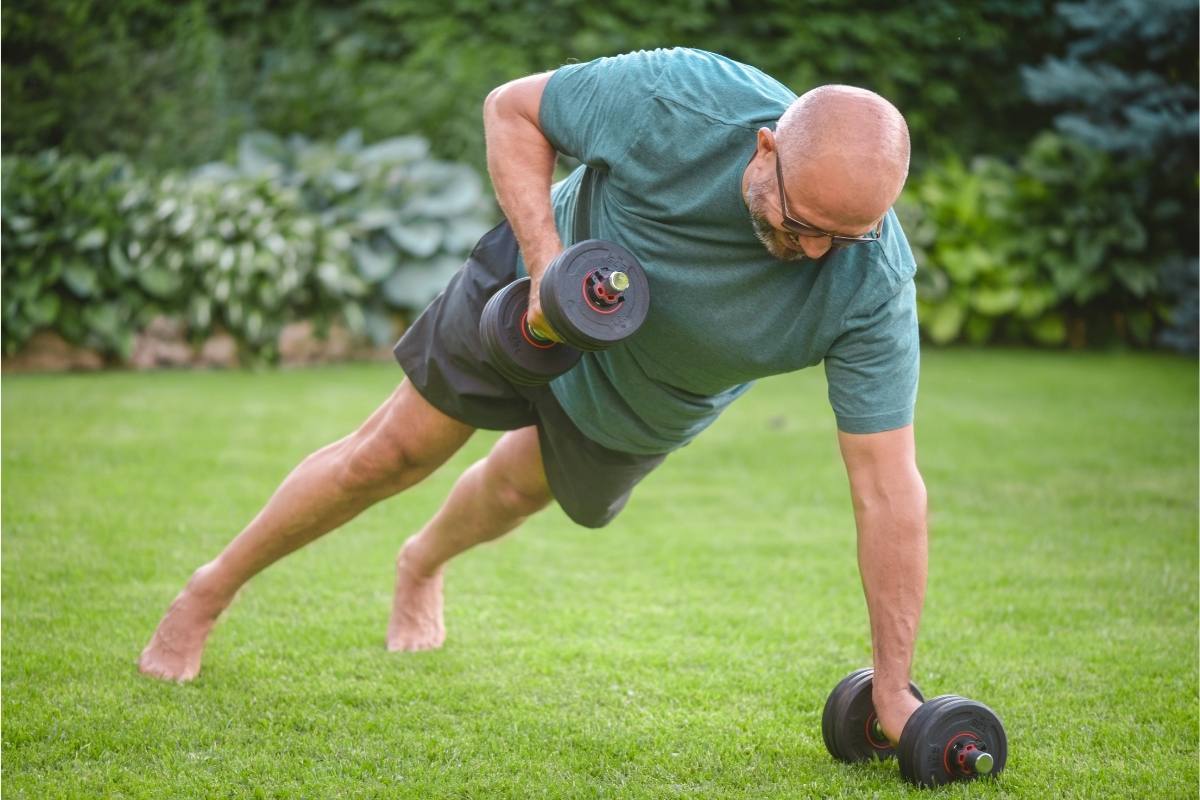 Man lifting weights on lawn