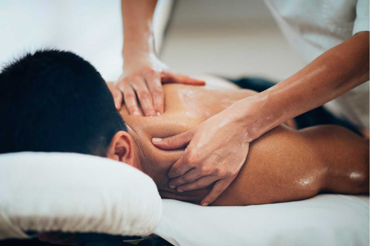 A man receiving remedial massage therapy for his back and neck