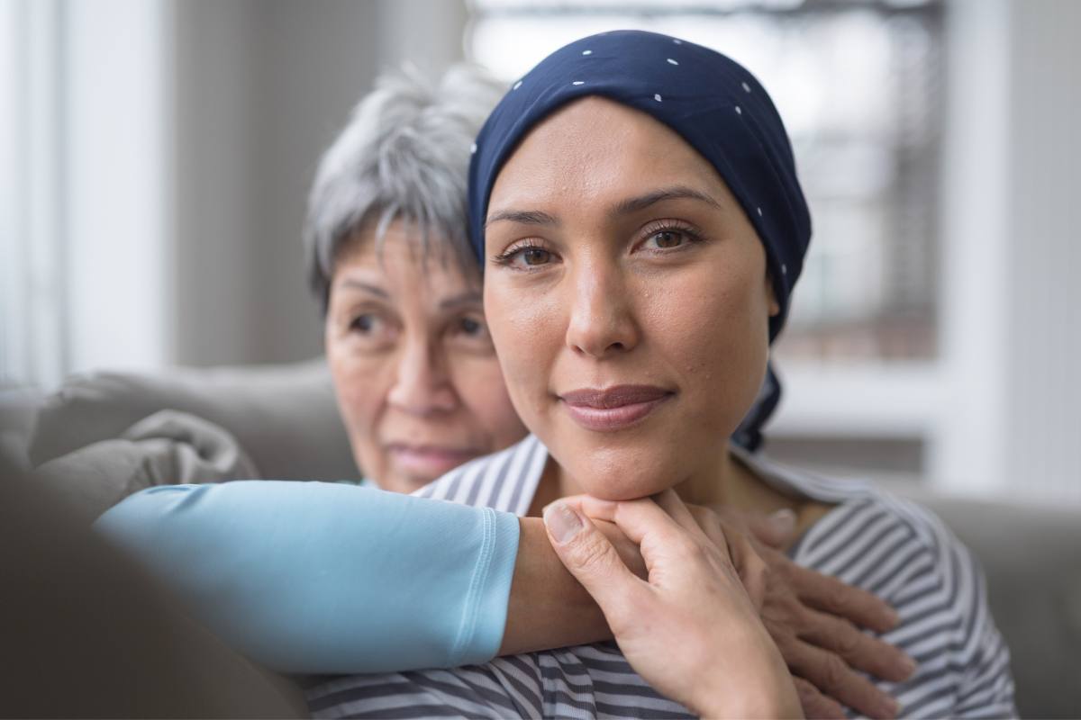 Woman fighting cancer sits lovingly with her mother